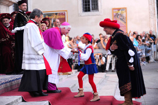 La delegazione di Porta Romana consegna il cero al Vescovo.
