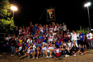 Foto di gruppo dei sestieranti con il palio Quintana di Agosto.