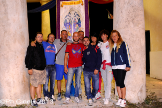 Lo staff della scuderia ed il Cavaliere posano davanti al palio in mostra al Sestiere.