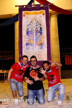 Tifosi posano davanti al palio in mostra al Sestiere.