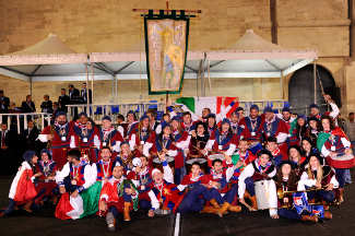 Foto ricordo di sbandieratori e musici con il palio di Campioni d'Italia 2014.