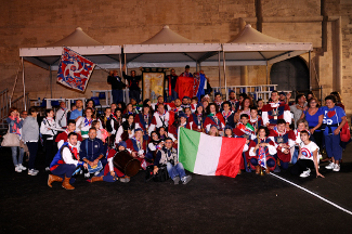 Foto ricordo di atleti e tifosi con il palio di Campioni d'Italia 2014.